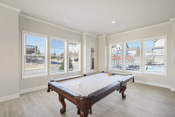 a room with pool table and windows