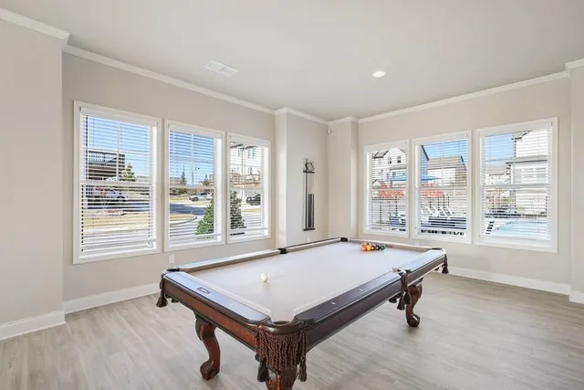 a room with pool table and windows
