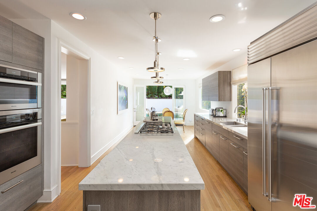 9770 San Circle Beverly Hills, CA 90210 - Photo 12 of 29 a kitchen with kitchen island a counter top space a sink stainless steel appliances and cabinets