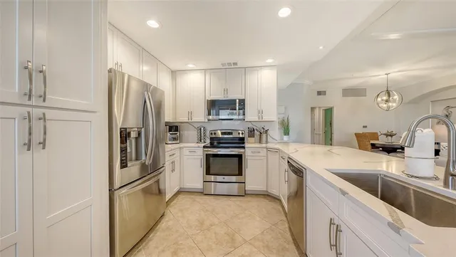 a view of a dining room with furniture a chandelier and wooden floor