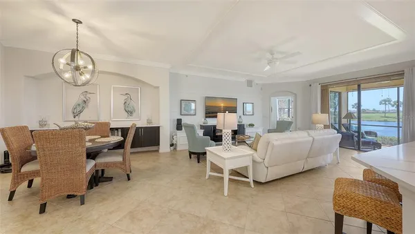 a living room with furniture kitchen view and a flat screen tv