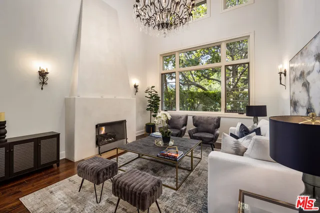 a living room with furniture a fireplace and a large window