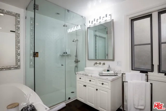 a bathroom with a double vanity sink mirror and shower