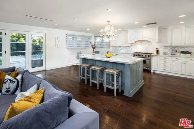 a kitchen with stainless steel appliances granite countertop a stove and a wooden floors