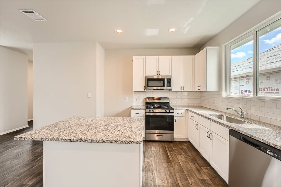 141 Bluestem Drive Elgin, TX 78621 - Photo 2 of 19 a kitchen with stainless steel appliances granite countertop a sink stove microwave and refrigerator