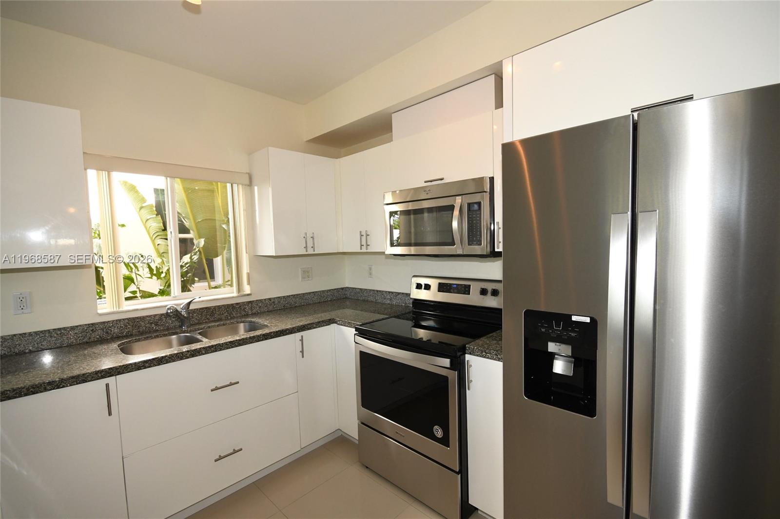2780 Southwest 33rd Avenue Miami, FL 33133 - Photo 19 of 52 a kitchen with stainless steel appliances a refrigerator sink and microwave