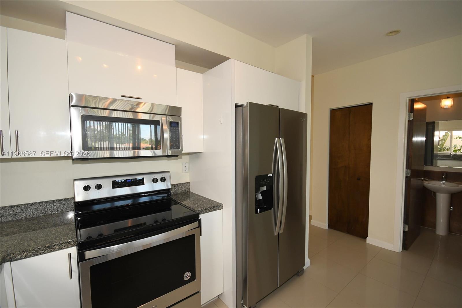 2780 Southwest 33rd Avenue Miami, FL 33133 - Photo 22 of 52 a kitchen with a stove and a refrigerator