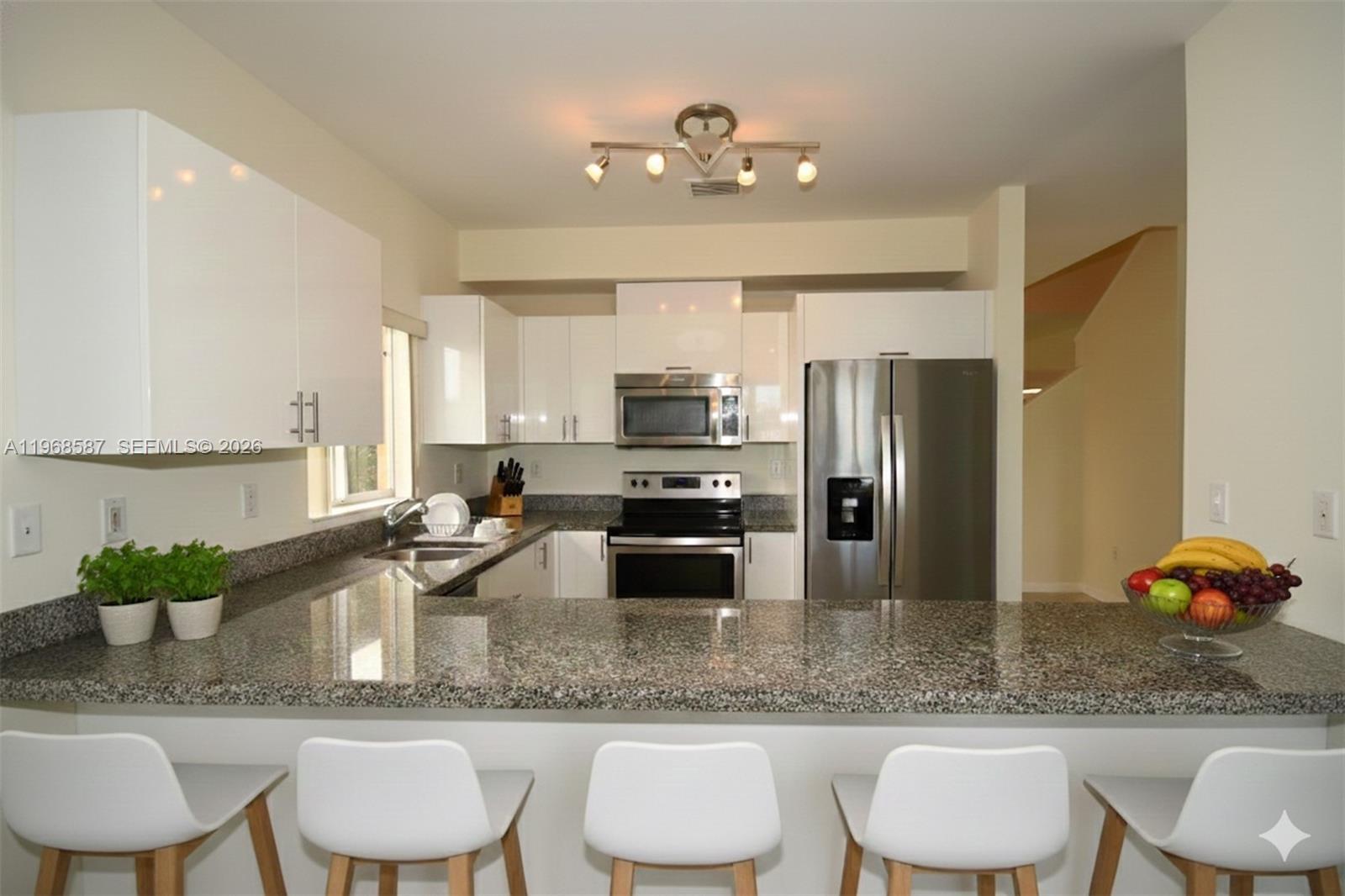 2780 Southwest 33rd Avenue Miami, FL 33133 - Photo 5 of 52 a kitchen with kitchen island granite countertop a counter space a sink and appliances