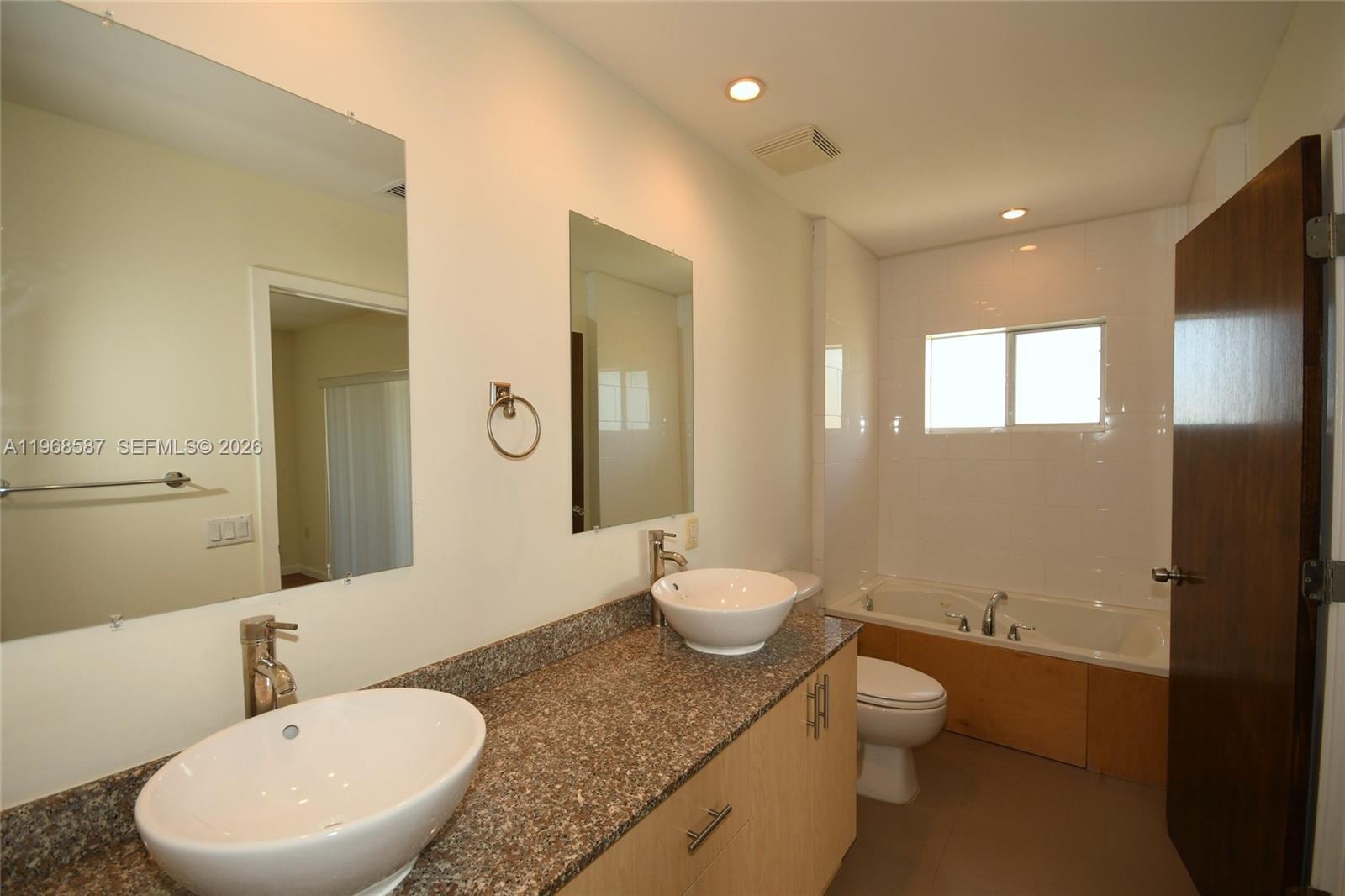 2780 Southwest 33rd Avenue Miami, FL 33133 - Photo 10 of 52 a bathroom with a granite countertop sink mirror vanity and a toilet
