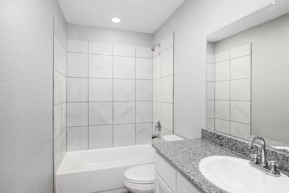 23338 Sandpiper Trail Spring, TX 77373 - Photo 7 of 11 a bathroom with a granite countertop bathtub shower sink vanity and toilet