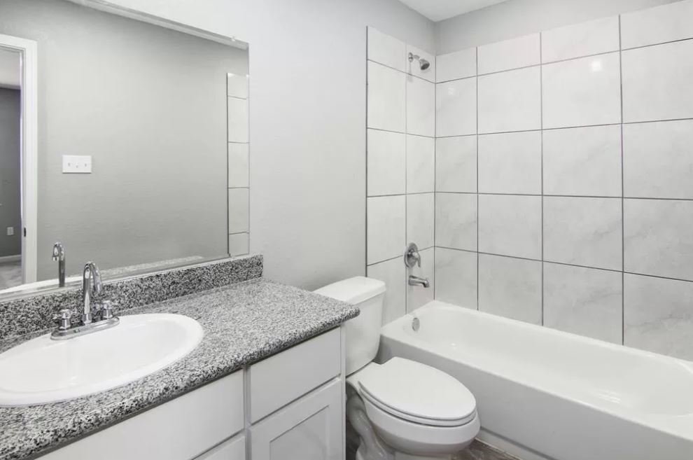 23338 Sandpiper Trail Spring, TX 77373 - Photo 8 of 11 a bathroom with a granite countertop sink a toilet and bathtub