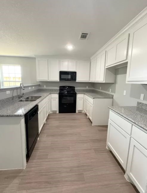 23338 Sandpiper Trail Spring, TX 77373 - Photo 9 of 11 a kitchen with stainless steel appliances granite countertop a stove top oven a sink dishwasher and a refrigerator with wooden floor