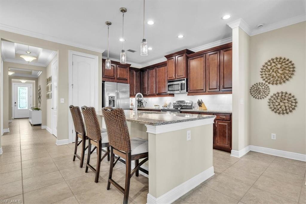 16424 Windsor Way Alva, FL 33920 - Photo 12 of 48 a kitchen with kitchen island a stove a table and chairs in it