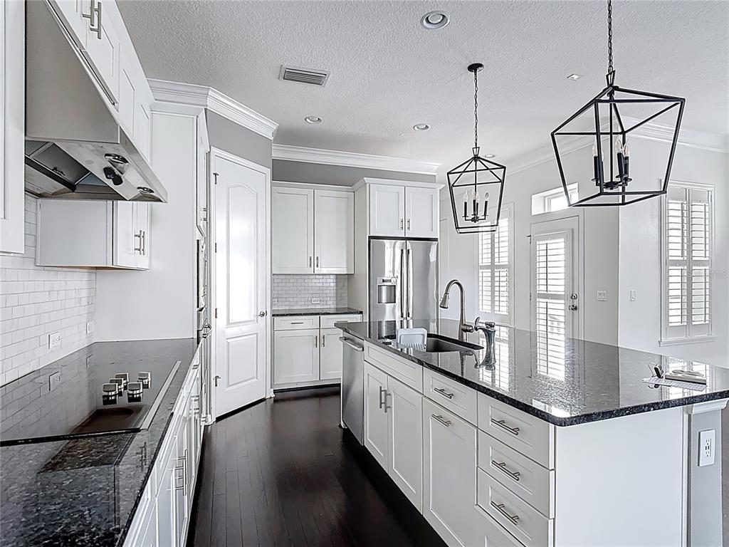1513 Resolute Street Celebration, FL 34747 - Photo 14 of 43 a kitchen with granite countertop a stove and a sink