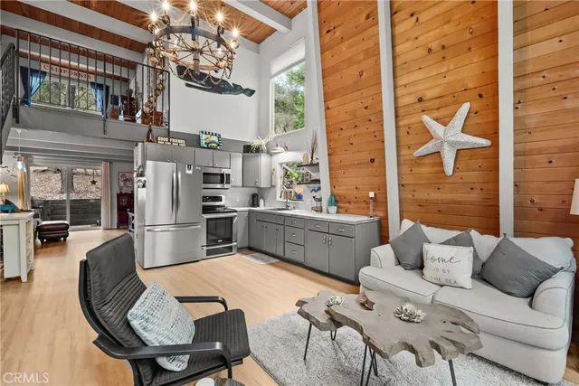 a kitchen with stainless steel appliances kitchen island granite countertop a refrigerator a stove and a dining table with wooden floor