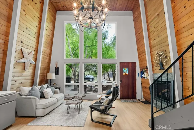 a living room with furniture a fireplace and a chandelier