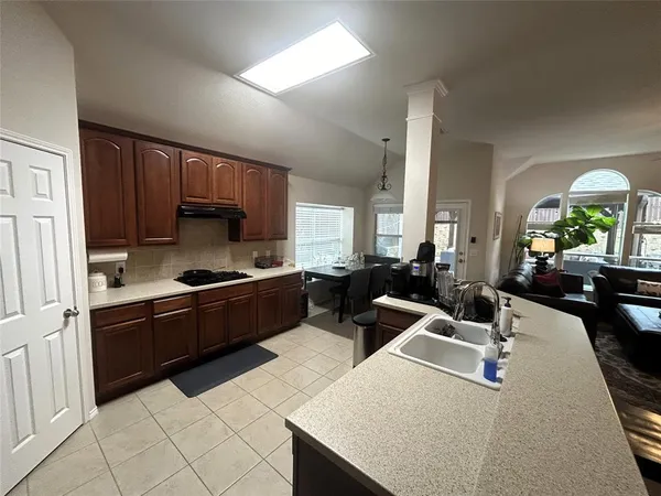 a kitchen with a sink a counter top space a stove and cabinets