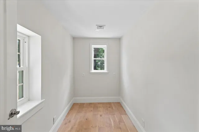 a view of a small space with wooden floor and a window