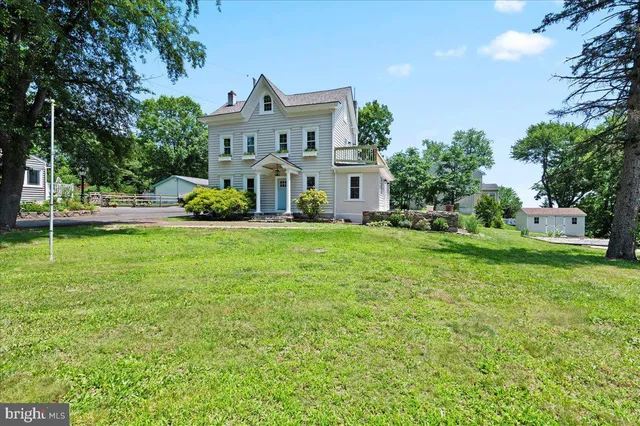 a view of a house with a big yard and large trees