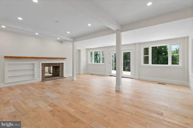 a view of an empty room with a fireplace and a window
