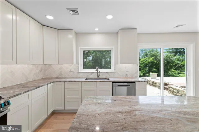 a large kitchen with lots of counter space sink and natural light