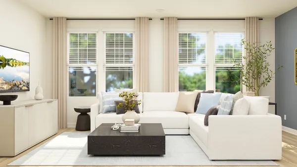 a living room with furniture and floor to ceiling windows