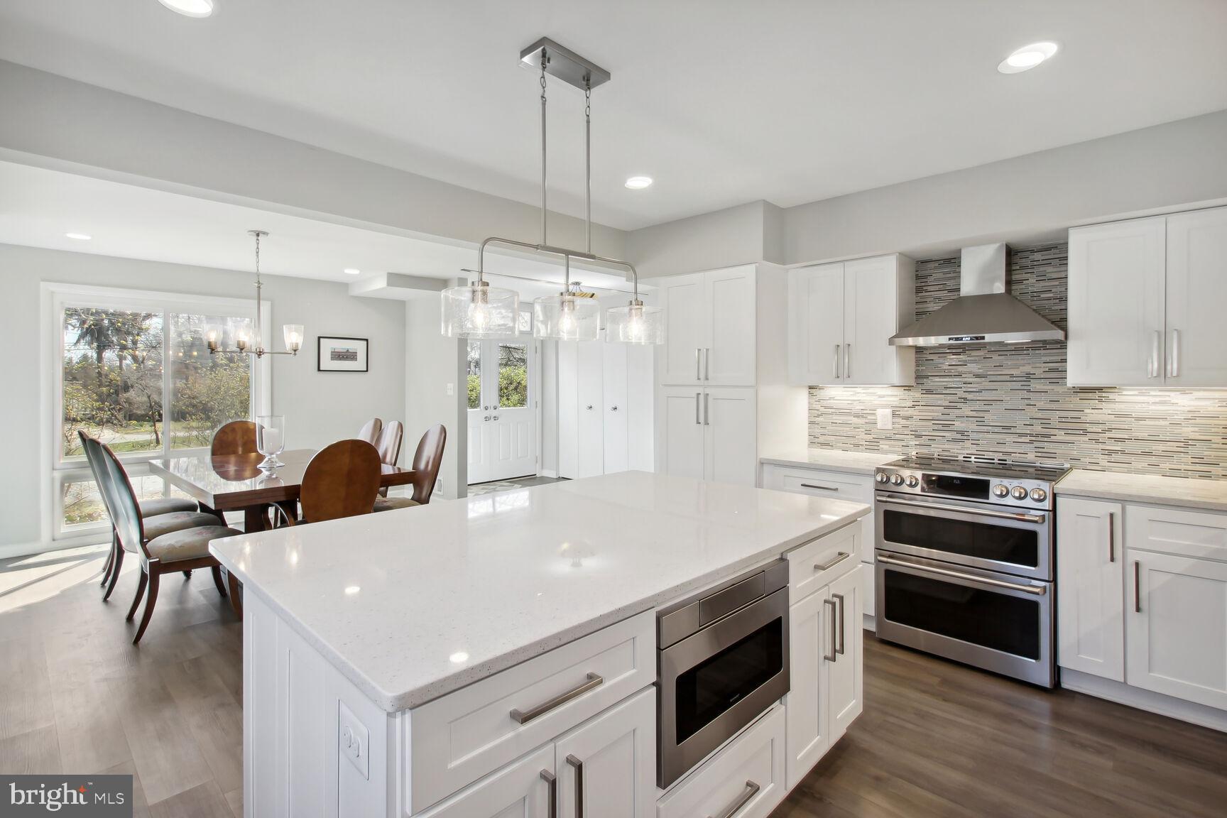 a kitchen with stainless steel appliances a kitchen island a stove a table and chairs