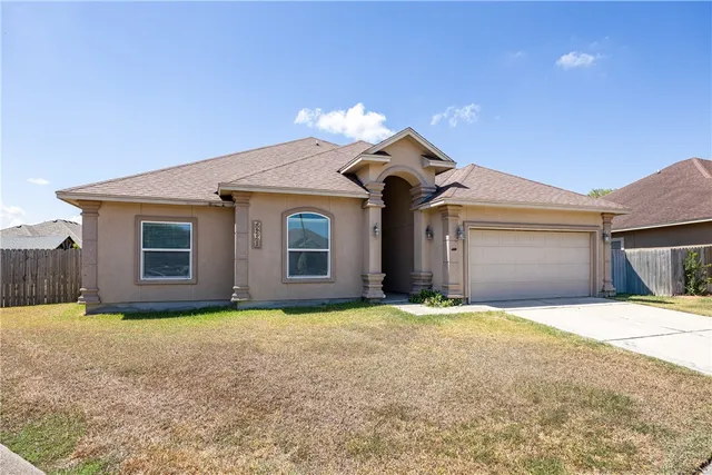 a front view of a house with yard and garage