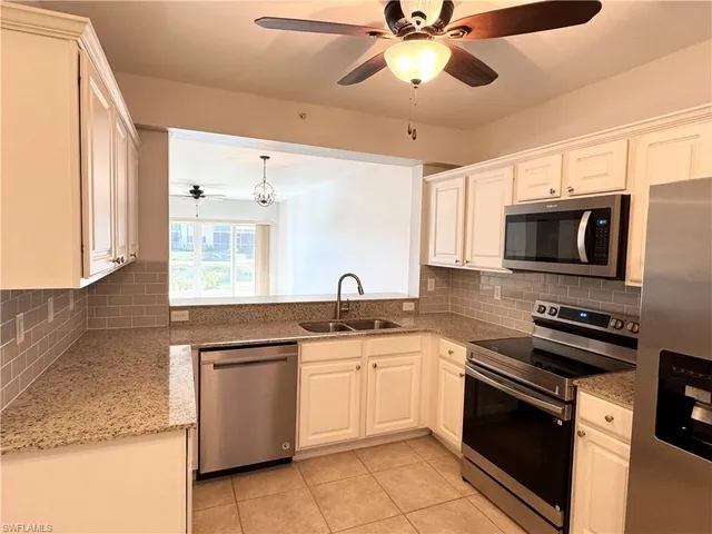a kitchen with stainless steel appliances granite countertop a sink and cabinets