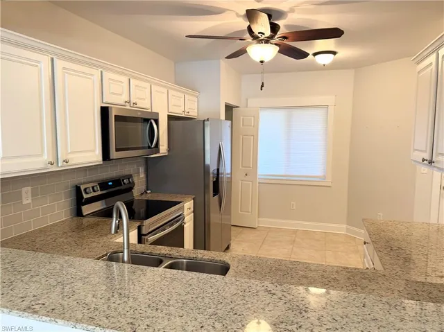 a kitchen with stainless steel appliances granite countertop a stove a microwave and a refrigerator