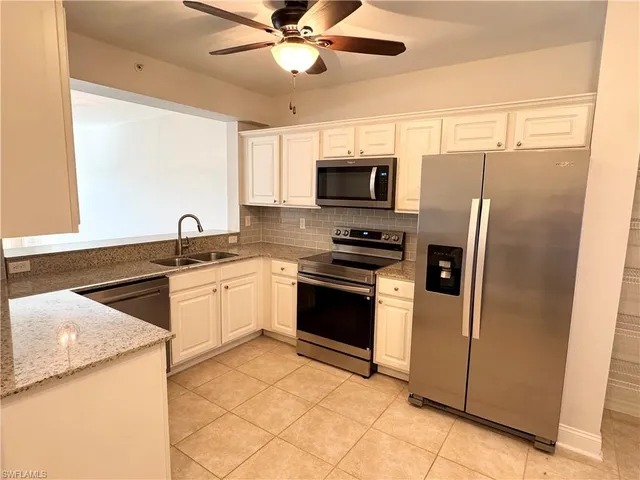 a kitchen with stainless steel appliances a refrigerator sink and microwave