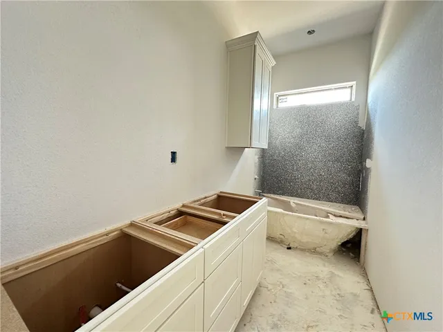 a bathroom with a granite countertop sink and a toilet