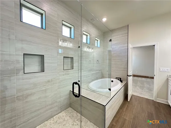 a bathroom with a tub a shower and a sink