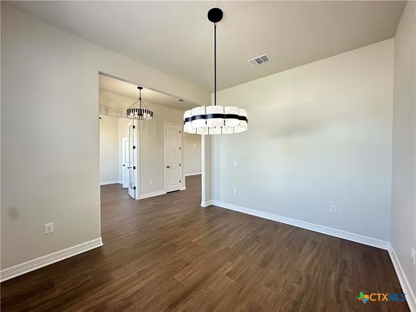 a view of a room with wooden floor a ceiling fan and a window