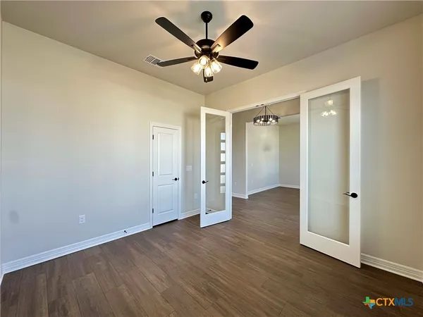 a view of an empty room with wooden floor