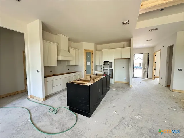 a kitchen with stainless steel appliances kitchen island granite countertop a refrigerator and cabinets