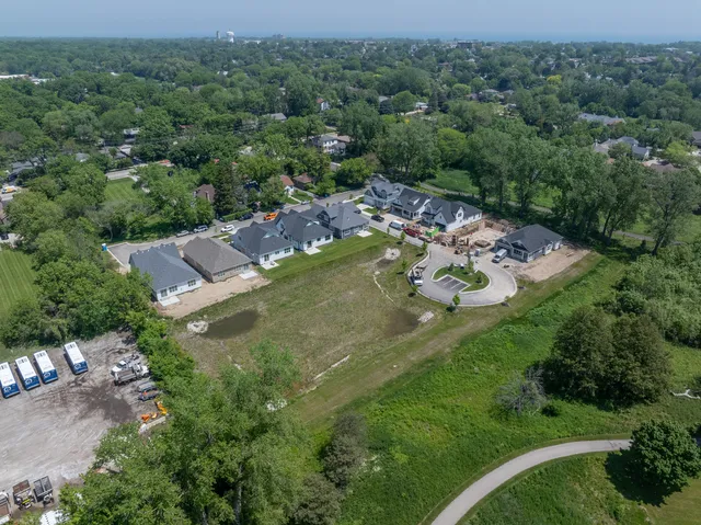 an aerial view of residential house with outdoor space and trees all around