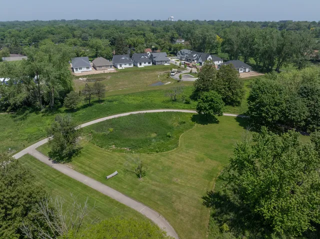 an aerial view of residential houses with outdoor space and trees all around