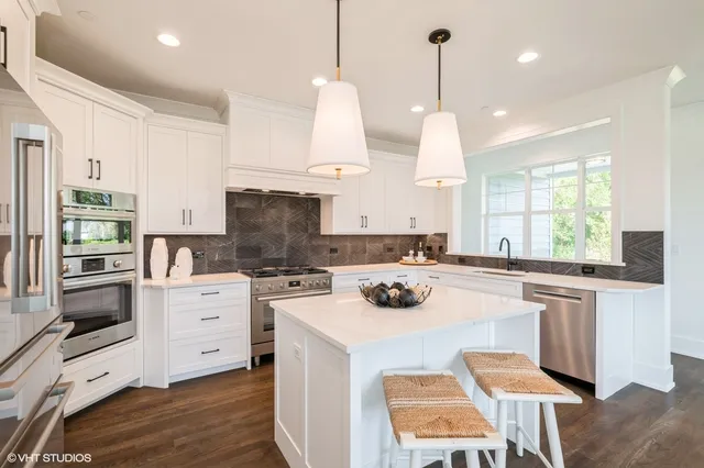 a kitchen with a stove a sink a center island and a wooden floor