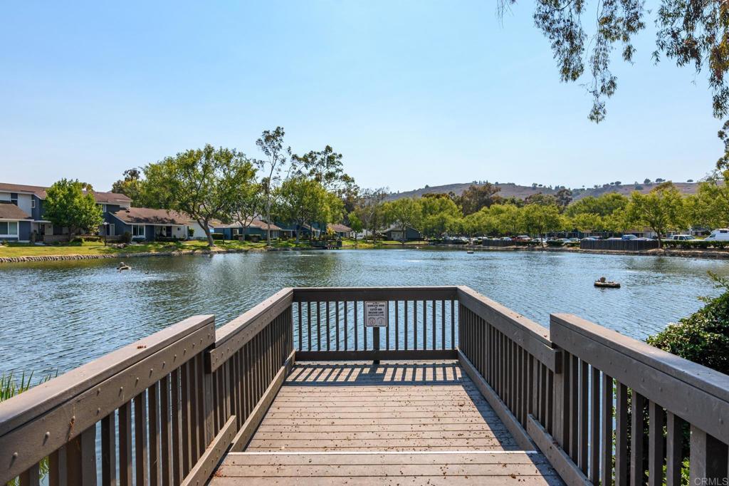 29302 Edgewood Road San Juan Capistrano, CA 92675 - Photo 54 of 57 a view of a lake with wooden stairs and bridge and tall buildings in the background