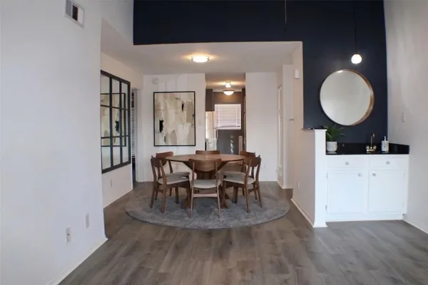 a view of a hallway with wooden floor and a bathroom