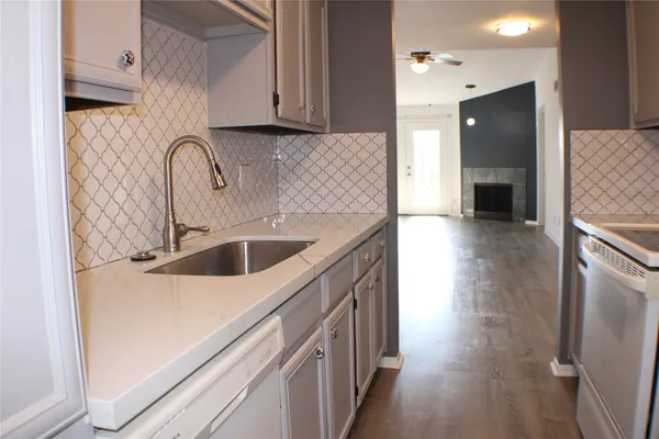 a kitchen with cabinets and wooden floor
