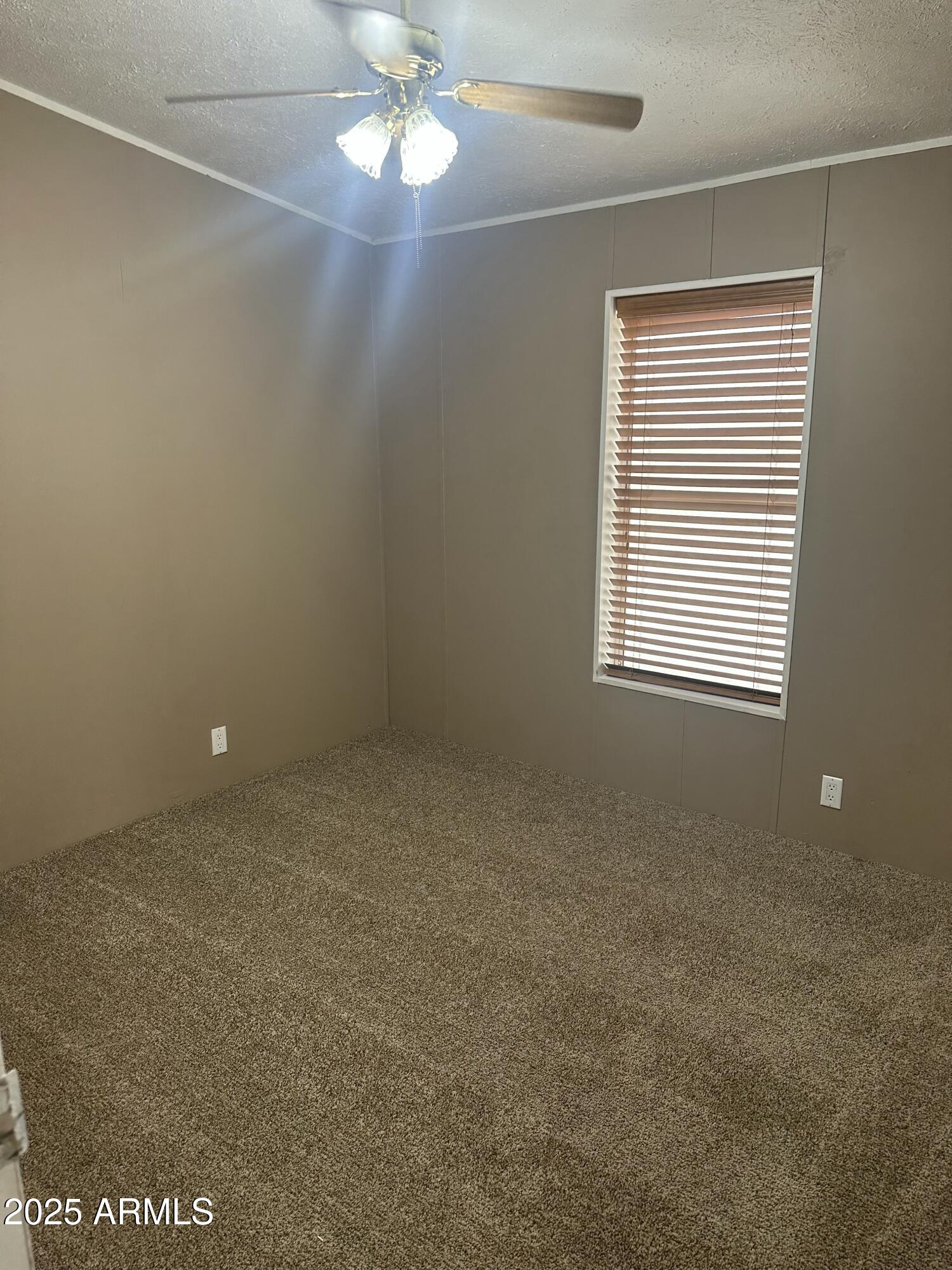 840 North Falton Road Maricopa, AZ 85139 - Photo 15 of 28 en empty room with windows and chandelier fan