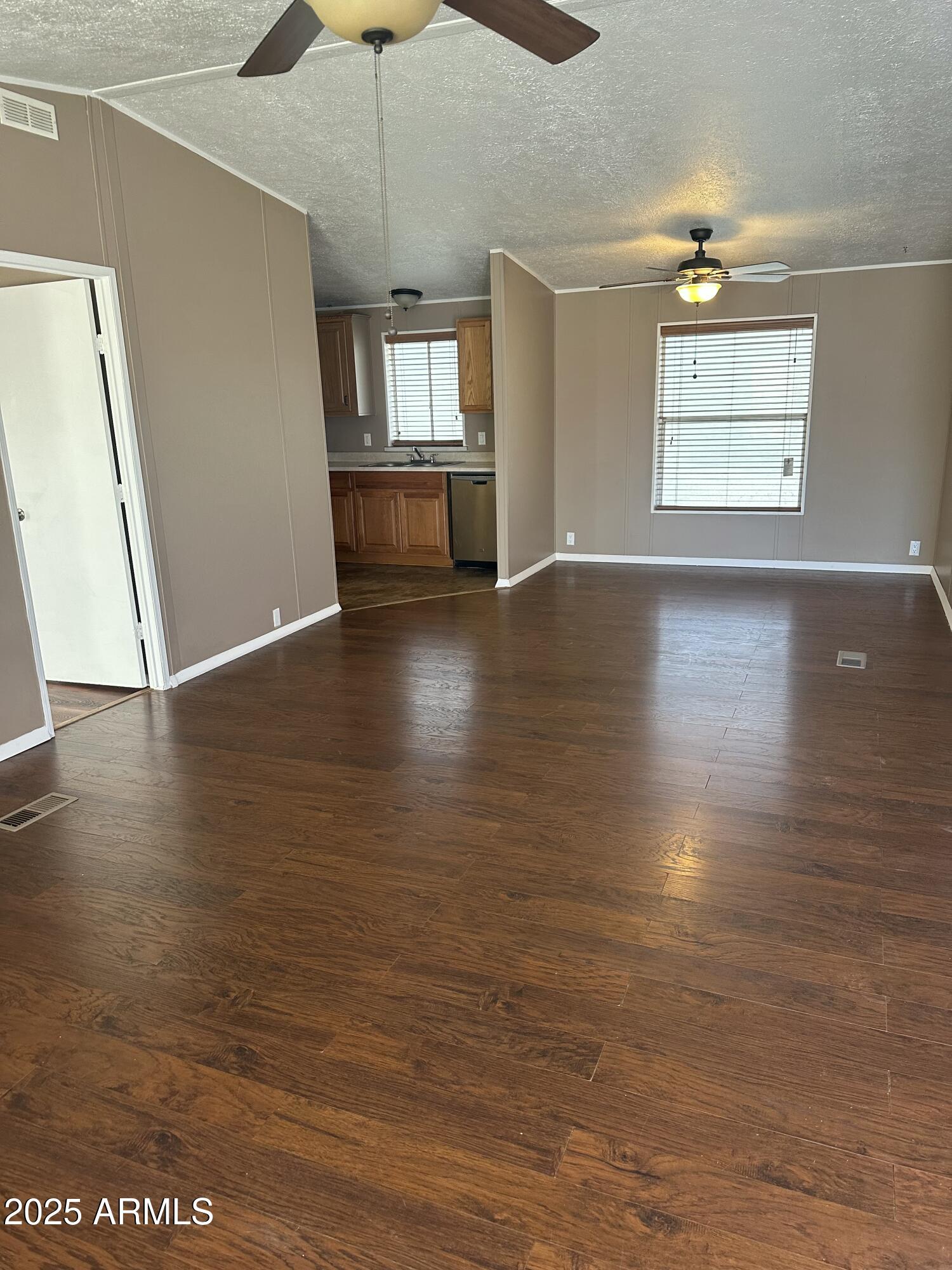840 North Falton Road Maricopa, AZ 85139 - Photo 3 of 28 an empty room with wooden floor fan and windows