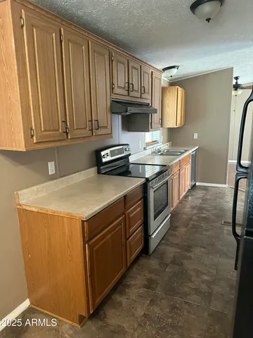 a kitchen with stainless steel appliances a stove a sink and a refrigerator