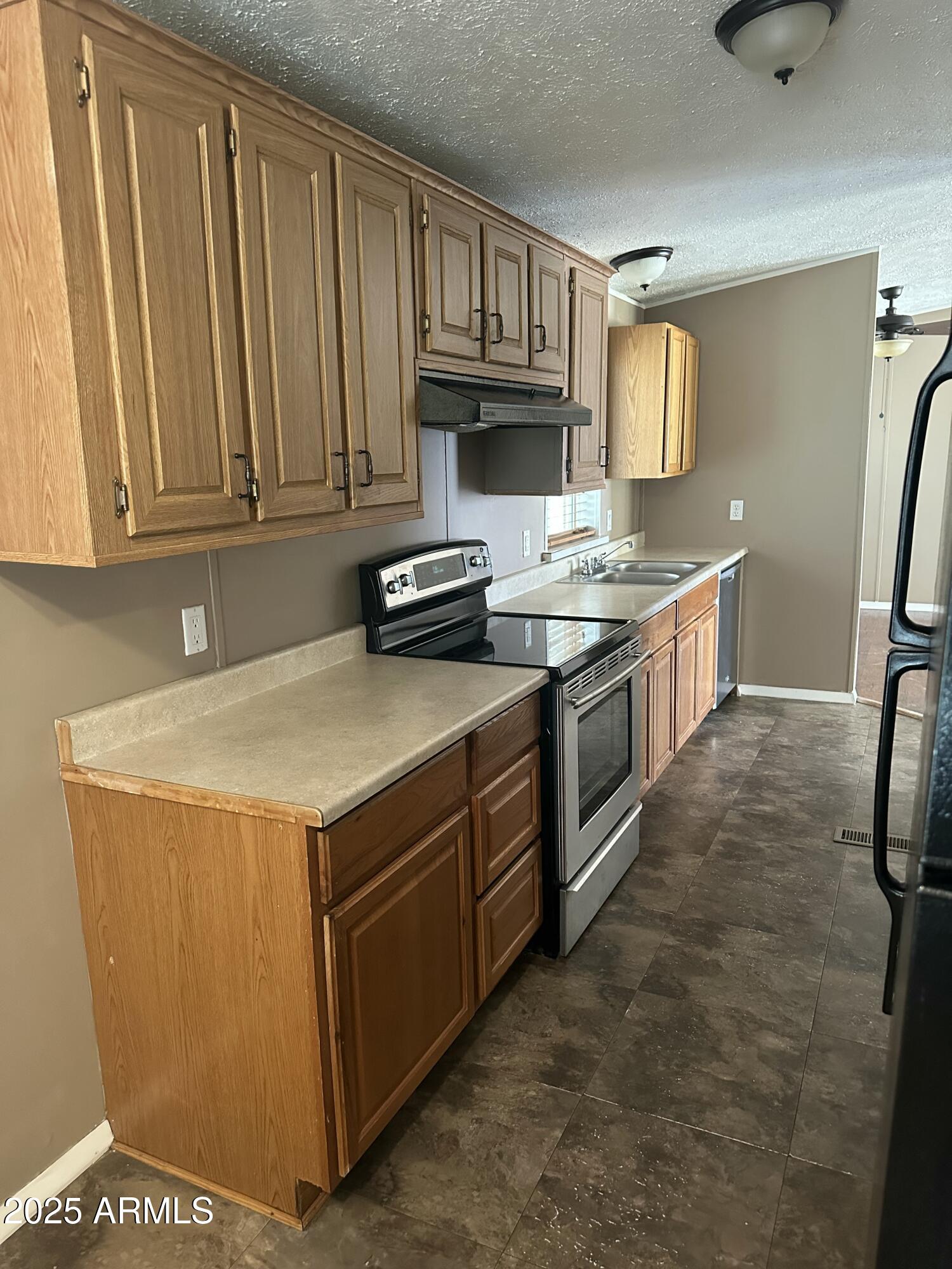 840 North Falton Road Maricopa, AZ 85139 - Photo 5 of 28 a kitchen with stainless steel appliances a stove a sink and a refrigerator