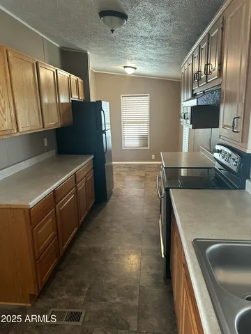 a kitchen with stainless steel appliances granite countertop a sink and a refrigerator