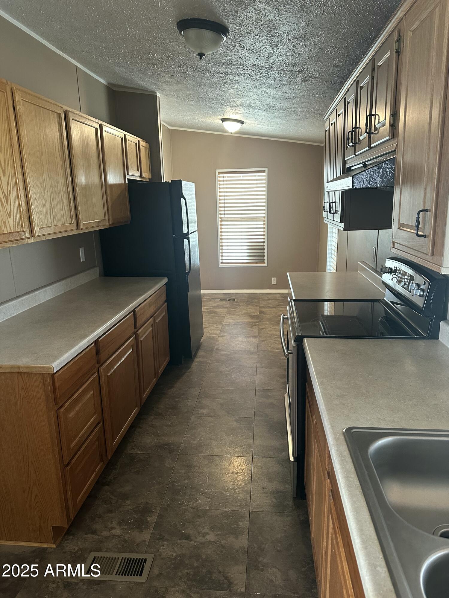 840 North Falton Road Maricopa, AZ 85139 - Photo 6 of 28 a kitchen with stainless steel appliances granite countertop a sink and a refrigerator