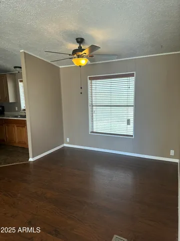 an empty room with wooden floor cabinet and windows