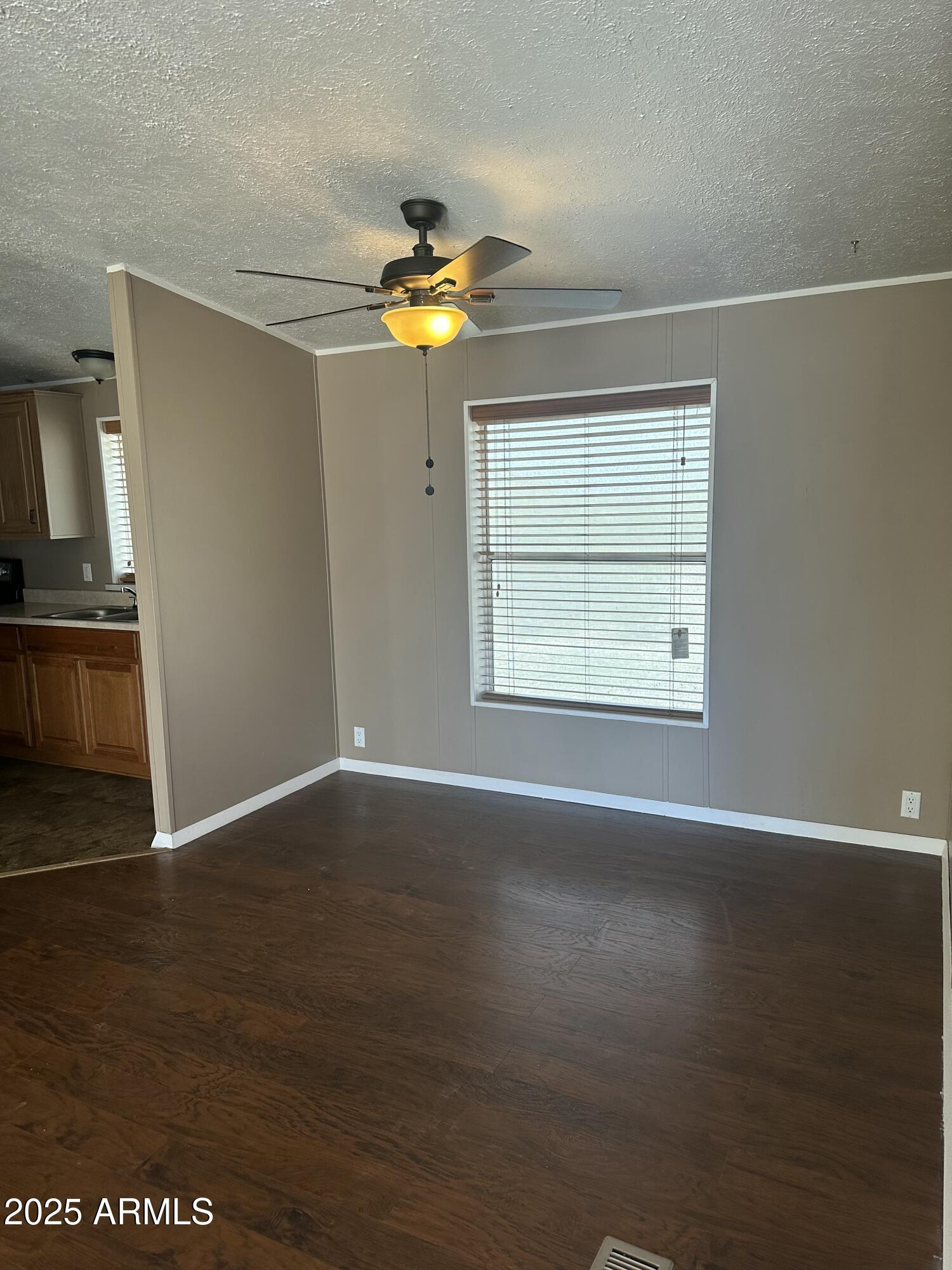 840 North Falton Road Maricopa, AZ 85139 - Photo 8 of 28 an empty room with wooden floor cabinet and windows